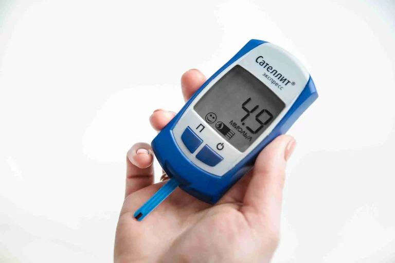 Hand holding a blood glucose meter used to monitor diabetes