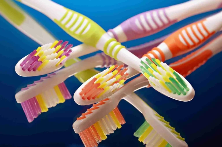 Assortment of colorful manual toothbrushes with different bristle types and head sizes