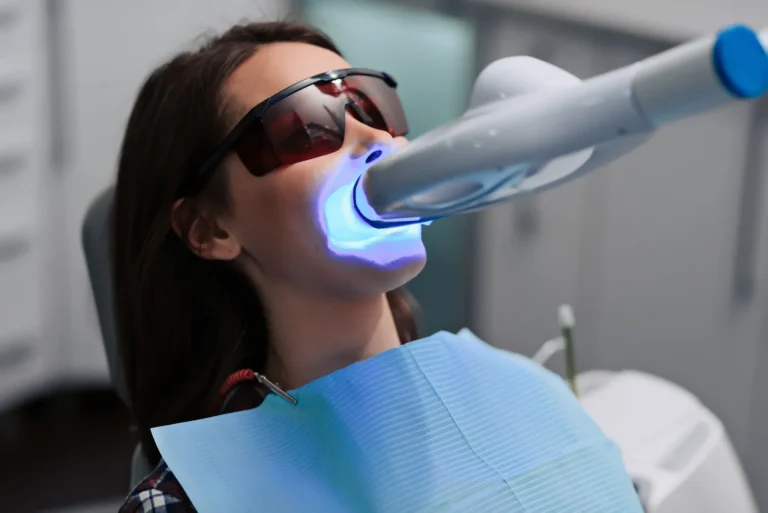 Patient wearing protective eyewear during in-office LED teeth whitening