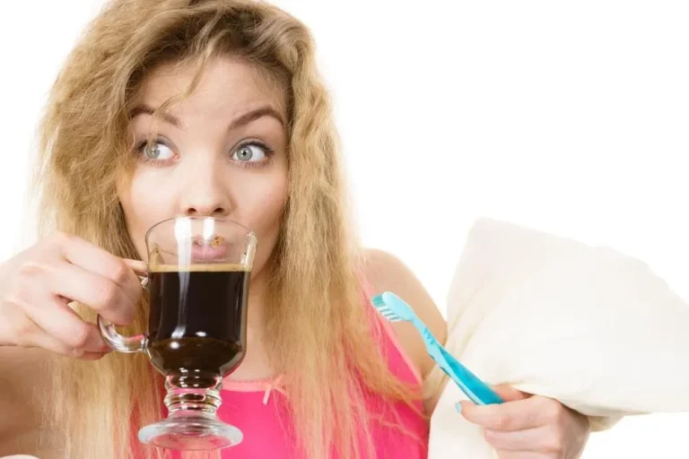 Woman drinking black coffee while holding a toothbrush